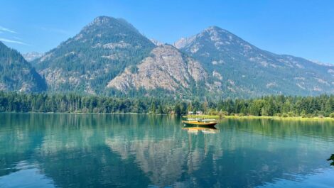 A waterfront view of Lake Chelan in Washington State on a summer day with mountains in the background.