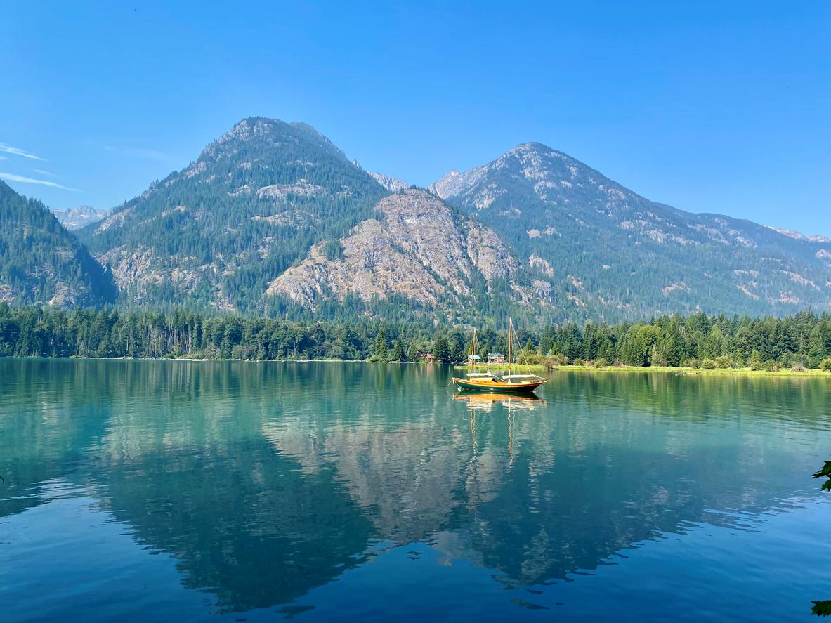 A waterfront view of Lake Chelan in Washington State on a summer day with mountains in the background.