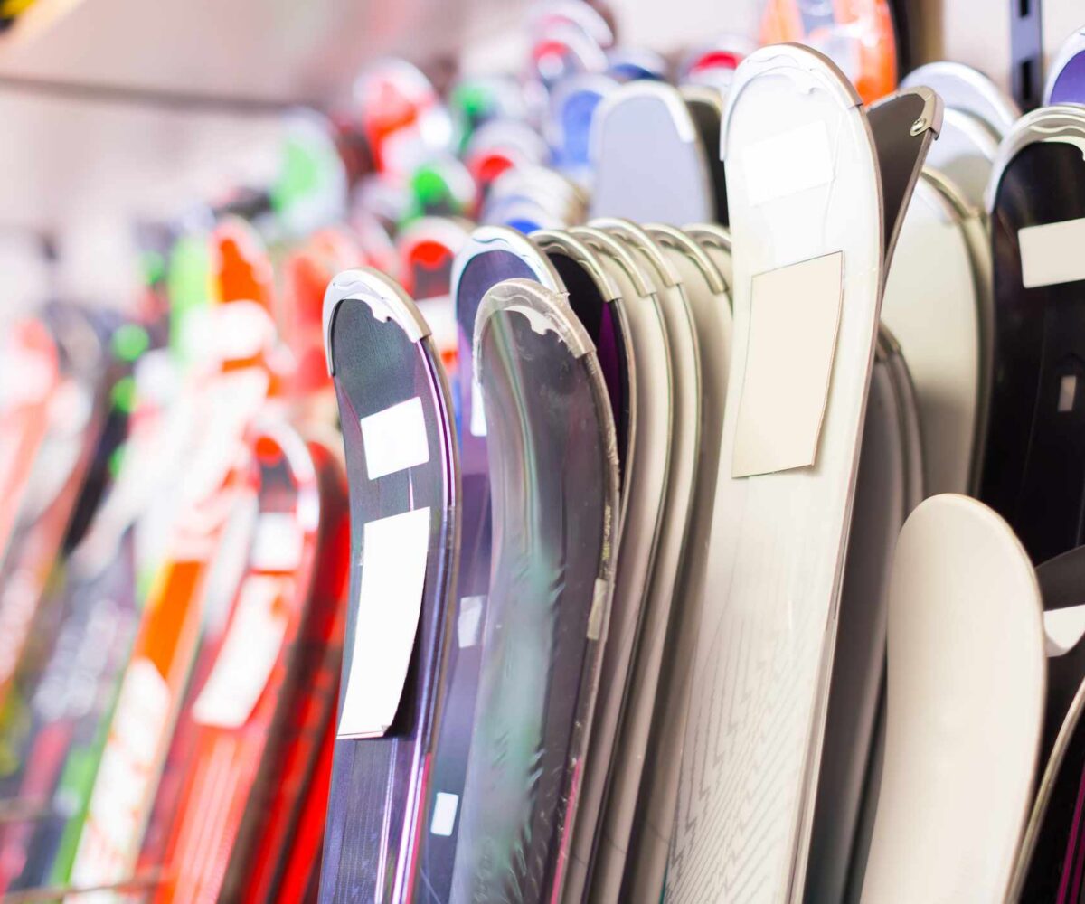 A large selection of skis arranged vertically on racks.